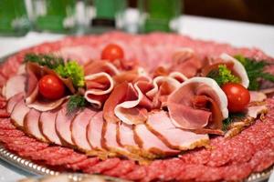 salsichas fatiadas de carne de presunto na mesa festiva foto