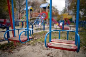um balanço solitário e vazio em um playground sem pessoas. foto