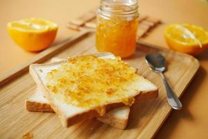 fruta laranja espalhada em um pão na mesa foto