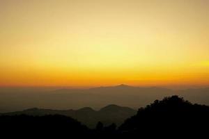 montanhas e vista do céu dourado à noite, quando o sol está prestes a se pôr. foco suave e seletivo. foto