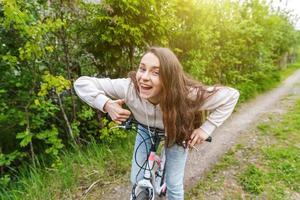 jovem andando de bicicleta no parque da cidade de verão ao ar livre. pessoas ativas. garota hipster relaxar e andar de bicicleta foto