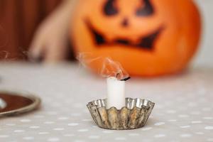 velas acesas fecham em um fundo de abóboras. lanterna de jack de cabeça de abóbora de halloween com velas acesas. abóboras de halloween iluminadas com velas na cozinha. foto