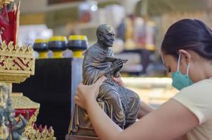 mulheres tailandesas asiáticas prestam homenagem à estátua de buda de acordo com antigas tradições de crença. foto