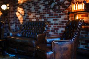 interior do sotão simulado parede de bloco cinza com cadeira de couro e lâmpada de fonte de luz vintage