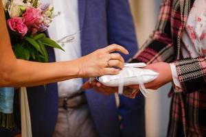 padre dando bênção a um casal em uma cerimônia de casamento em uma igreja foto