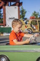 um menino dirigindo um carro infantil. emoções alegres. crianças, retrato. foto