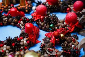 decorações de natal, vela, nozes, cones, canela, maçãs, estrela em um fundo de madeira. humor de feriado. foto