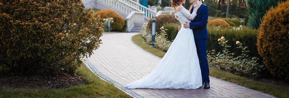 noiva e noivo no dia do casamento caminhando ao ar livre na primavera natureza casal de noivos feliz recém-casado foto