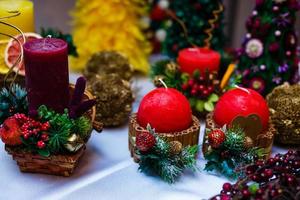vela decorada com paus de canela e maçãs vermelhas, decoração de natal foto