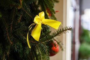 feliz árvore de natal guirlanda dourada decoração de fita verde abeto closeup foto