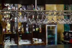 copos vazios para bebida alcoólica acima de um fundo de rack de bar