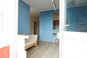 interior moderno da sala com poltrona no fundo da parede azul foto