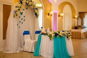 decoração de casamento de mesa e cadeiras dos noivos com flores e tule foto