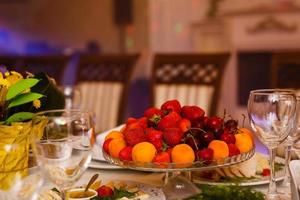 decoração de frutas de mesa de casamento no restaurante, abacaxi, morango, mesa de buffet de uvas morango foto