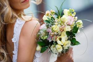 buque de noiva. a noiva. linda de flores brancas e vegetação, decorada com fita de seda, encontra-se na cadeira de madeira vintage foto