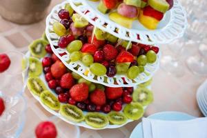 decoração de frutas de mesa de casamento no restaurante, abacaxi, morango, uva foto