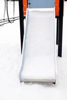 slide vazio coberto de neve na rua, no playground foto
