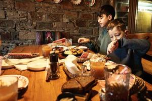 família tendo uma refeição juntos no autêntico restaurante ucraniano. dois irmãos comem. foto