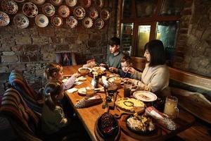 família tendo uma refeição juntos no autêntico restaurante ucraniano. foto