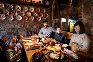 família tendo uma refeição juntos no autêntico restaurante ucraniano. foto