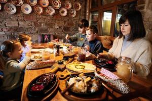 família tendo uma refeição juntos no autêntico restaurante ucraniano. foto