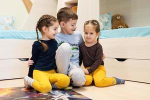 crianças conectando peças de quebra-cabeça em um quarto infantil no chão de casa. diversão em família atividade lazer. foto