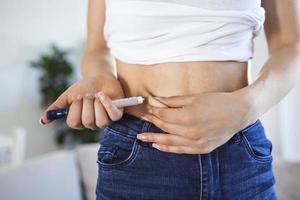 um paciente diabético usando caneta de insulina para fazer uma injeção de insulina em casa. diabetes de controle jovem. estilo de vida diabético foto