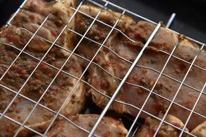 carne de porco em conserva crua em uma malha de ferro. rede para grelhar churrasco. deliciosa carne de porco crua. foto