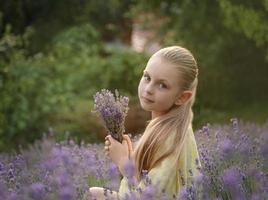 linda garotinha no campo de lavanda. foto