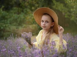 linda garotinha no campo de lavanda. foto