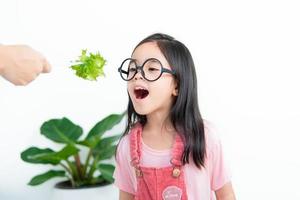 crianças menina ásia comendo legumes foto