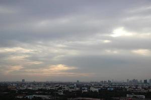 céu nublado de tempestade escura em dia chuvoso com fundo de construção de cidade foto