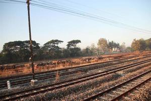 trilhos de trem da janela externa na zona rural com céu pôr do sol foto