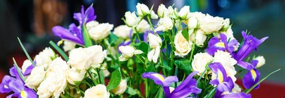 lindo buquê de íris azuis e rosas brancas em um vaso foto