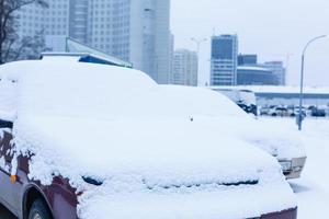 carros cobertos de neve durante uma nevasca de inverno foto
