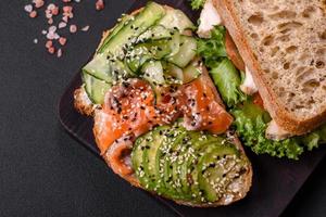 sanduíche saboroso fresco com salmão, abacate e gergelim e sementes de linho foto