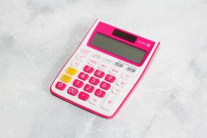 calculadora rosa sobre fundo branco para o conceito financeiro de negócios foto