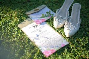 um par de sapatos de noiva e convite de casamento para uma cerimônia de casamento tradicional na indonésia foto