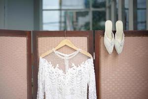 lindo vestido de noiva da noiva e um par de sapatos para uma cerimônia de casamento tradicional na indonésia foto