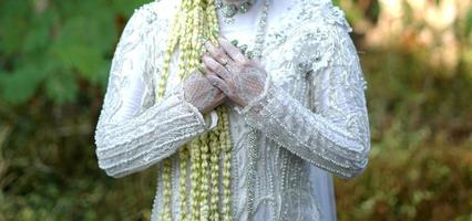 noiva segurando colar de flor de jasmim e magnólia cerimônia de casamento tradicional foto