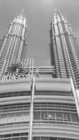 kuala lumpur-02-28-2016, imagem em preto e branco vertical, céu escuro acima do topo das torres gêmeas petronas. fevereiro em kuala lumpur, malásia. foto