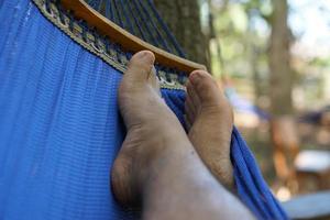 pés do homem deitado na cama de férias foto
