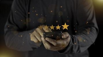 satisfação de perto na mão do cliente pressionando na tela com ícone de feedback de classificação de cinco estrelas e nível de imprensa classificação excelente para dar o melhor ponto de pontuação para revisar o conceito de serviço foto