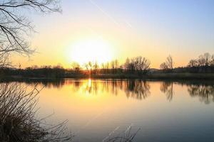 panorama do pôr do sol no lago foto