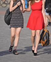 duas lindas garotas estão andando na rua foto