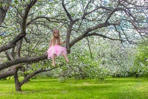 menina adorável na macieira florescendo foto