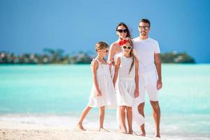 família de quatro pessoas nas férias de verão na praia foto