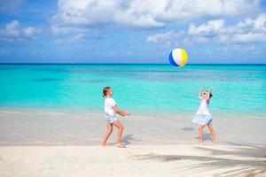 adoráveis meninas brincando com bola na praia foto