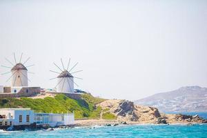 vista famosa dos moinhos de vento gregos tradicionais na ilha de mykonos ao nascer do sol, cyclades, grécia foto