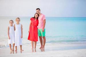 jovem família de férias na praia do Caribe foto